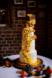 3 lagen bruidstaart met gele bloemen en gouden besjes