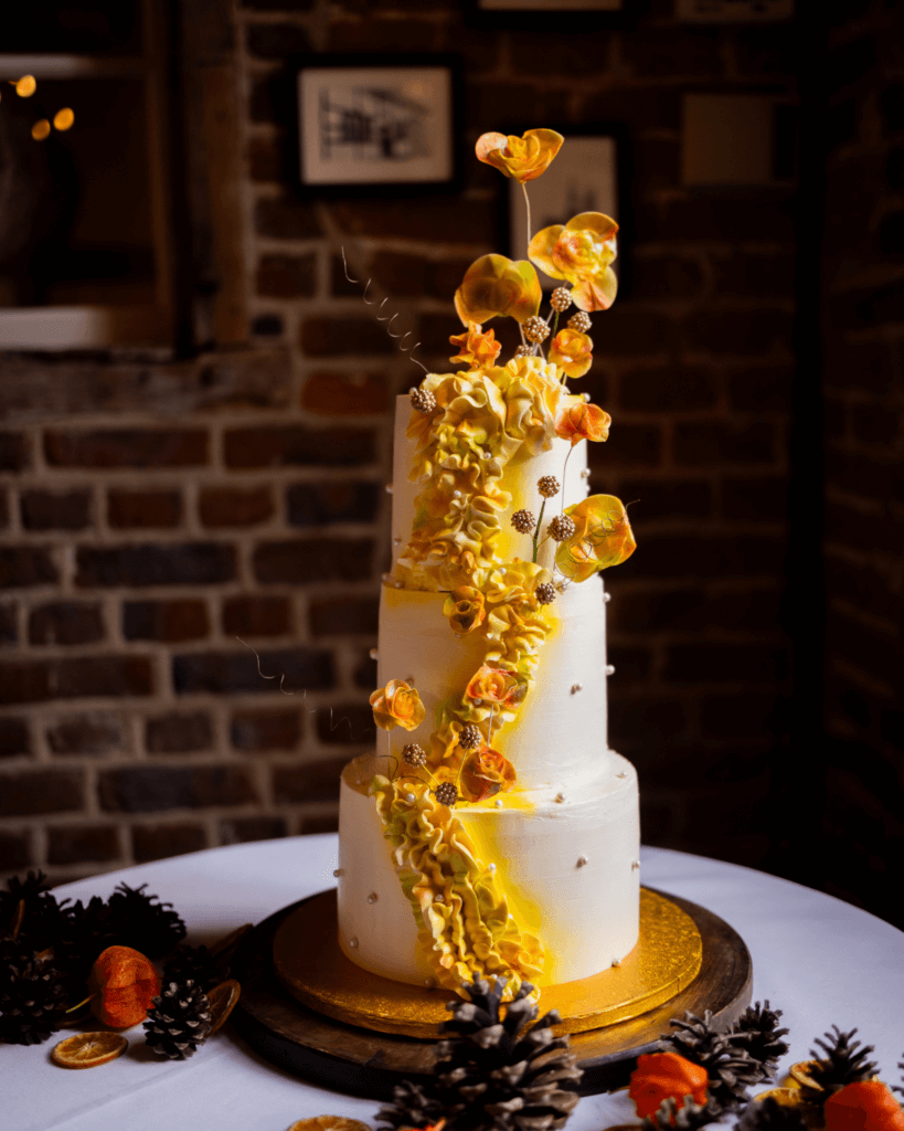 Drie-lagen bruidstaart van Deliscu Patisserie De Luxe met gele rozen, vastgelegd door Photos by Jill bij Schinvelderhoeve in Limburg